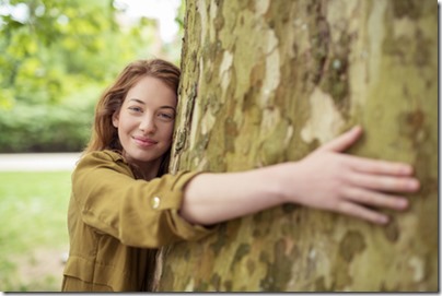 une femme enlace un arbre pour se reconnecter avec la nature